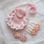 handmade crochet set includes a pink daisy-adorned sling bag and matching flower hair clips