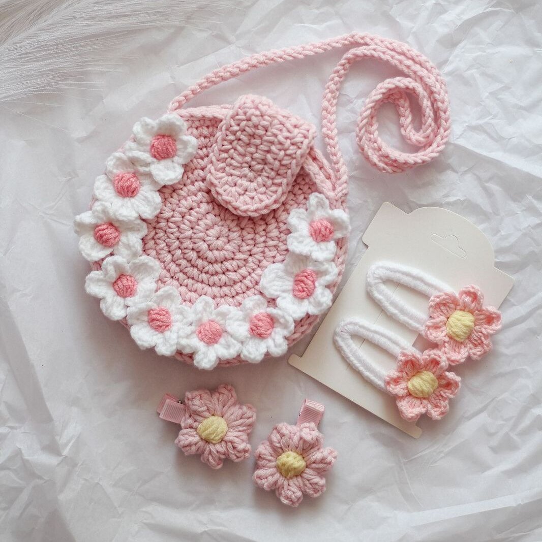 handmade crochet set includes a pink daisy-adorned sling bag and matching flower hair clips